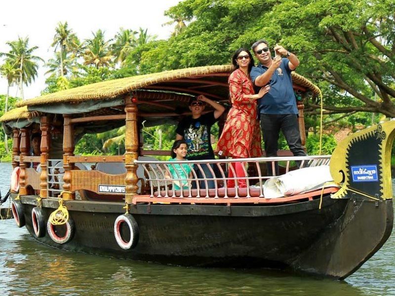 A family enjoying the backwaters on a shikkara boat in Alleppey, Kerala